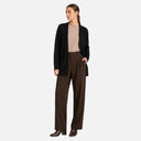 Modelo con chaqueta de punto larga negra de Freequent sobre conjunto elegante.