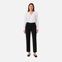 Modelo con pantalón recto de vestir Freequent en color negro combinado con blusa blanca.