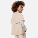 Vista trasera de capa de punto color crudo para mujer con gran solapa sobre los hombros y cuello alto de Surkana.