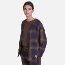 Modelo llevando chaqueta de cuadros de Studio Manna con pantalón a juego en tonos azul marino y marrón.