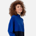 Primer plano del cuello perkins de canalé del jersey azul de punto Surkana con detalle en contraste verde lima.