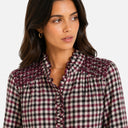 El detalle que hace especial a esta blusa: cuello ligeramente fruncido con acabado ondulado y canesú trabajado con smock artesanal que aporta textura y volumen a la parte superior.