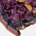 Detalle del pañuelo de seda estampado para mujer Surkana en tonos burdeos, marron, negro y mostaza