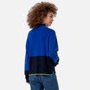Vista trasera del jersey de punto bicolor azul y azul marino para mujer con cuello perkins y detalles en verde lima.