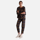 Modelo con pantalón de cuadros azul marino y marrón de Studio Manna combinado con chaqueta a juego y zapatillas blancas.