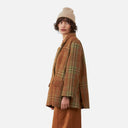 Vista lateral del abrigo de cuadros Orfeo para mujer con corte amplio y diseño en tonos marrones y verdes