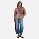 Modelo con blusa Feeka de cuadros y volante delantero combinada con pantalón vaquero.