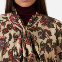 Detalle del tejido estampado floral y lazada al cuello de blusa Orfeo para mujer