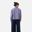 Blusa corta de rayas azules Orfeo para mujer vista trasera combinada con pantalón vaquero ancho