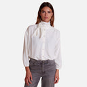 Camisa blanca Studio Manna con lazada anudada al cuello y cierre delantero de botones.