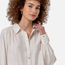 Detalle del cuello camisero, los frunces en los hombros y el tejido fluido de la camisa Surkana.