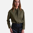 Modelo llevando camiseta verde oliva con lazada en el cuello de Studio Manna