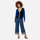 Cárdigan de punto bicolor Surkana en azul, verde y marino combinado con pantalón vaquero.
