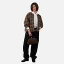 Chaqueta acolchada de cuadros Orfeo para mujer con corte amplio y mangas con volumen, combinada con pantalón negro.