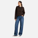 Modelo con chaqueta corta marrón de Freequent con cuello camisero y bolsillos delanteros.