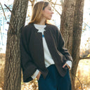 Chaqueta de lana marrón PAN Producto Básico combinada con pantalón azul marino en un entorno natural.