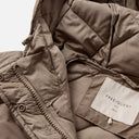 Detalle del acolchado y acabado interior del abrigo Freequent en topo Desert Taupe