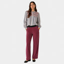 Modelo con pantalón de pana granate de Jarman combinado con blusa de rayas.