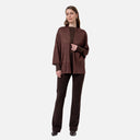 Pantalón largo de punto Surkana en color chocolate combinado con camiseta y chaqueta de punto.