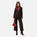 Pantalón de punto Surkana en color chocolate combinado con blusa estampada roja.