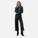 Pantalón de punto Surkana en color melange oscuro combinado con blusa verde de lunares.