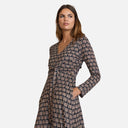 Vestido estampado de Studio Manna con escote en pico y nudo frontal que estiliza la silueta.